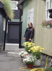 Sara ved et hus i Tjørnuvik